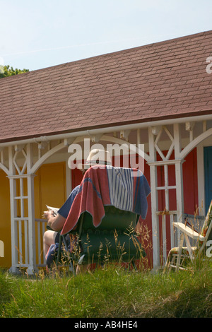 A man relaxing by his beach hut in Scarborough, Yorkshire, UK. Stock Photo