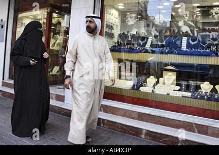 arab couple walking by a jewelry shop, gold souk, Dubai Stock Photo