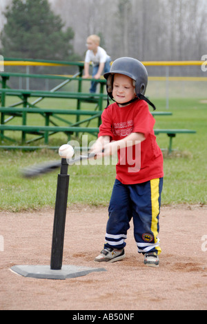 5 year old boys and girls learn how to play baseball by participating in a T ball league for tots Stock Photo