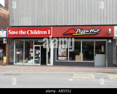 High Street Brentwood Essex Save the Children Charity Shop located next to a Pizza Hut fast food restaurant Stock Photo