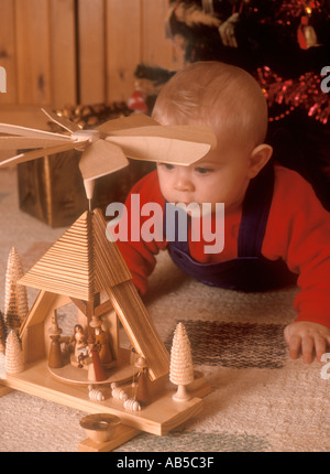 6 months old baby boy looking at a Christmas crib Stock Photo