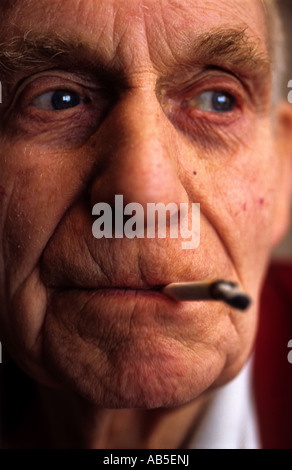 Old aged pensioner smoking a hand rolled cigarette, UK. Stock Photo