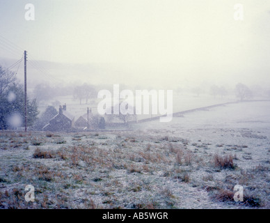 Snow storm; view over fields towards Falstone village from Yarrow, Northumberland National Park, England, UK. Stock Photo