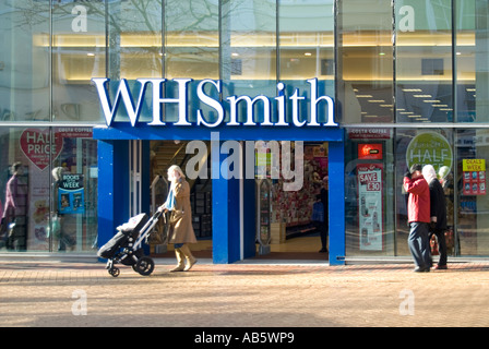 City of Chelmsford shoppers pedestrianised high street retail business premises & modern glass shop front of W H Smith store sign Essex England UK Stock Photo
