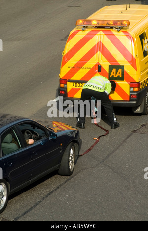 Aerial view AA breakdown recovery business driver high vis jacket connect tow rope his yellow van to move broken down car from middle lane London UK Stock Photo