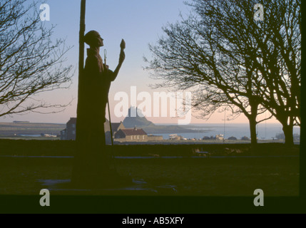 Statue of St Aidan with Lindisfarne Castle beyond, Holy Island, Northumberland, England, UK. Stock Photo