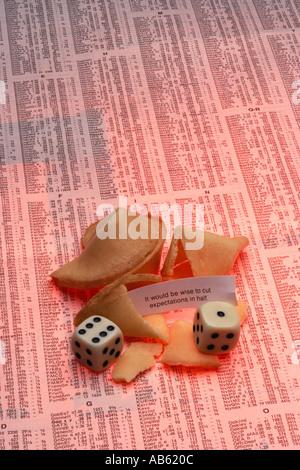 Fortune Cookies with fortune and dice on stock investmnt table from newspaper Stock Photo