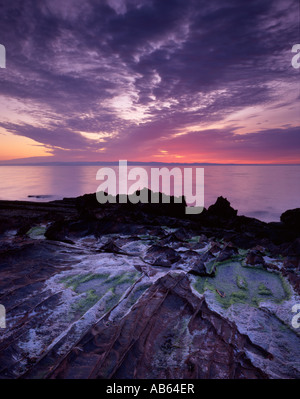 Sunrise over Ayrshire from Pirates cove, Corrie, Arran. Stock Photo