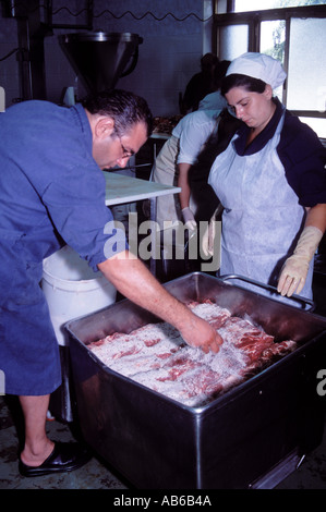 Italian workers seasoning and preparing the Pork while working in a Salami factory in Campania Southern Italy Stock Photo