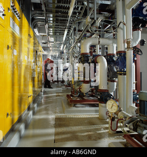 Office block plant room showing pipework for boilers and air conditioning units plus electrical switchgear cabinets Stock Photo