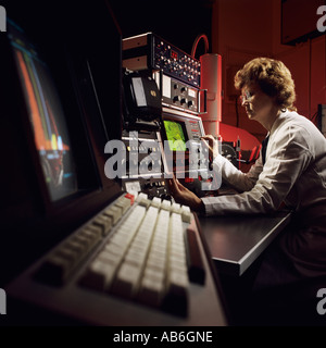 Woman scientist operating electron microscope in UK research laboratory Stock Photo