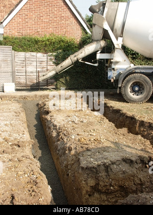 Ready mix truck completed one concrete pouring into trench fill foundations in Essex clay soil for new build detached house on single building plot UK Stock Photo