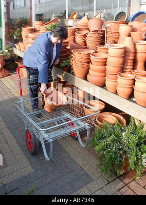 Harlow Essex garden centre 61 sixty one year old lady selecting garden pots Stock Photo