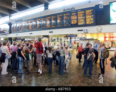 Euston Main Line Railway Station terminal main interior concourse arrival departure board group of school children & adult minders London England UK Stock Photo