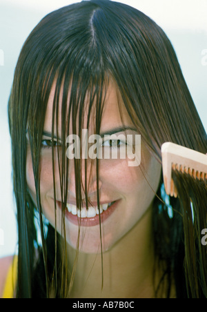 Woman combing her hair Stock Photo
