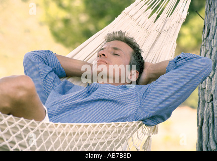 Man lying in hammock Stock Photo