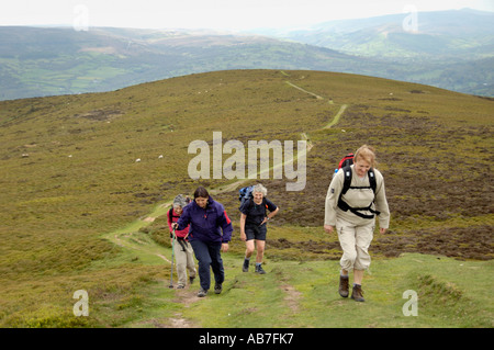 Group of women part of guided walking group on steep path to Sugar Loaf mountain Abergavenny Monmouthshire South Wales UK