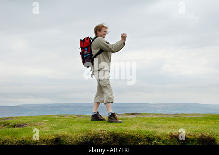 Lady taking photo of view from top of Sugar Loaf mountain Abergavenny Monmouthshire South Wales UK Stock Photo