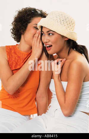 two young asian girlfriends gossip, isolated on white Stock Photo - Alamy