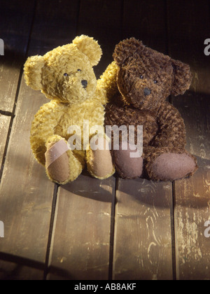 two teddy bears sitting on timber floor board Stock Photo