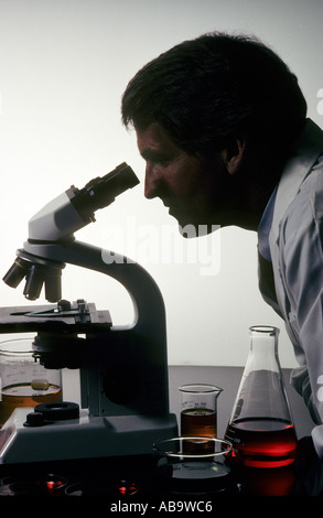 lab technician looking through microscope Stock Photo