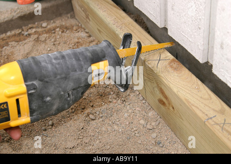 Cutting a plank with a reciprocating saw Stock Photo
