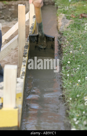 Using a spade to level out wet concrete in a form Stock Photo
