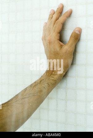 Man's hand on shower wall Stock Photo