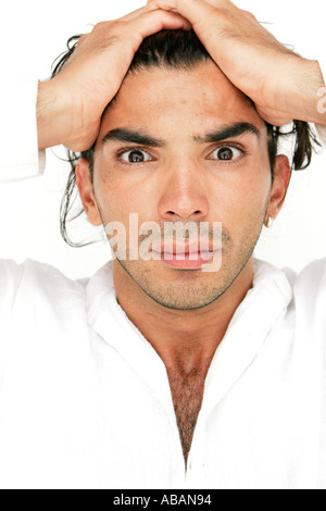 young man with hands on head looking at camera surprised Stock Photo
