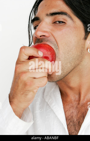 young man eating a peach Stock Photo