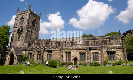 People relaxing on the grass in front the Holy Trinity Church Skipton North Yorkshire Stock Photo