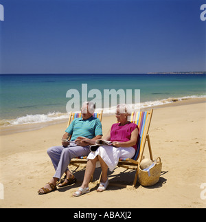 Elderly Couple in Deckchairs on Beach Stock Photo