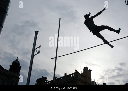 Silhouetted athlete clearing the bar during a pole vault event 'Prazska Tycka' on Wenceslas square in Prague, Czech Republic Stock Photo