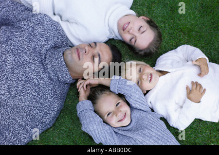 Family lying on the grass Stock Photo