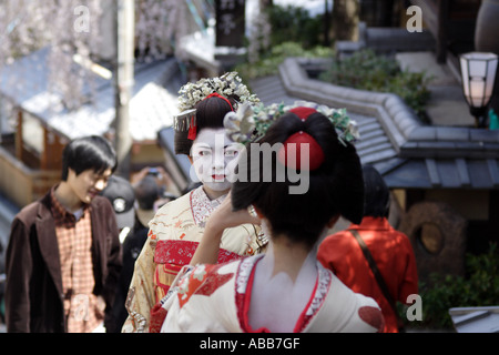 Kyoto, Japan, Geisha Taking a Photo for Tourists During Cherry Blossom Festival Stock Photo