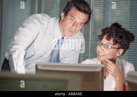 Businessman and businesswoman looking at computer screen Stock Photo