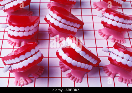 Teeth with feet on red grid Stock Photo