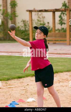 school girl throwing shot putt on school sports day Stock Photo