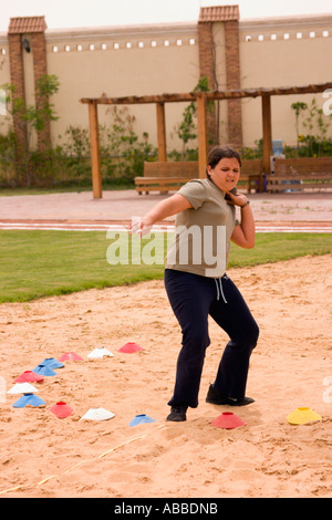 school girl throwing shot putt on school sports day Stock Photo