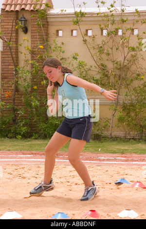 school girl throwing shott putt on school sports day Stock Photo