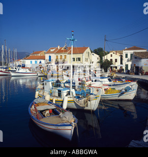 Fishing boats moored in harbour with cafes shops and houses on quayside Fiscardo Cephalonia Island Greek Islands Greece Stock Photo