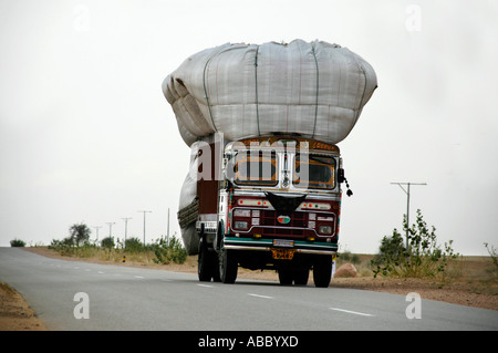Overloaded lorry Tata driving down the street Thar desert near Jaisalmer Rajasthan India Stock Photo