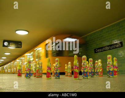 A group of easter bunnies from chocolate standing on a subway platform in front of an arriving subway train, U Gesundbrunnen Stock Photo