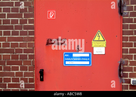 Red, yellow, white and blue labels on red door Stock Photo