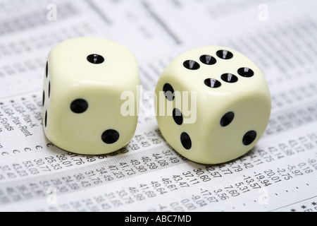 Dices lying on share price chart in a newspaper Stock Photo