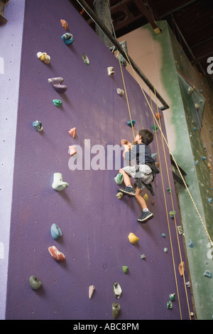 6 year old boy shows bravery and determination while climbing at challenging  indoor rock climbing facility, Model Released Stock Photo