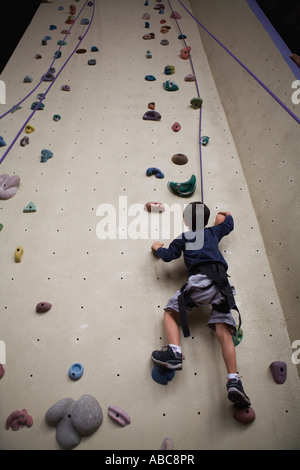 6 year old boy shows bravery and determination while climbing at challenging  indoor rock climbing facility, Model Released Stock Photo