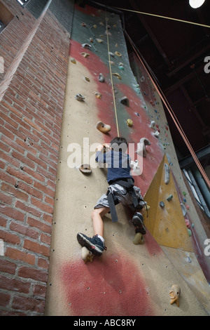 6 year old boy shows bravery and determination while climbing at challenging  indoor rock climbing facility, Model Released Stock Photo