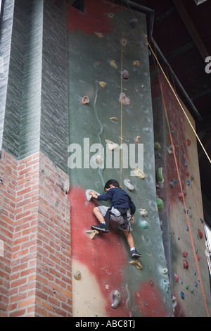 6 year old boy shows bravery and determination while climbing at challenging  indoor rock climbing facility, Model Released Stock Photo