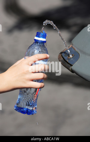 hand filling up water in a plastic bottle at a public spring fresh water fountain in paris Stock Photo